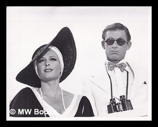 Item #368769 Photo Still: of woman in large black straw hat and pearl necklace and man in...